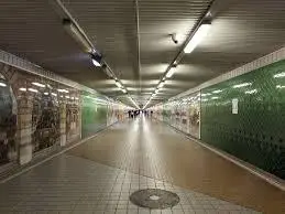 Devonshire Street Tunnel beneath Sydney Central Station featuring historic tiled walls, pedestrian walkway and heritage railway murals.