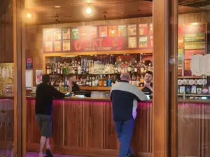 The Coopers Hotel front bar in Newtown, featuring colourful cocktail menus, a lively atmosphere and the eclectic character of Sydney's Inner West.