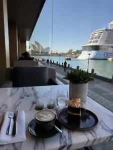 Coffee and cake overlooking Sydney Harbour at Park Hyatt Sydney, with views of the Sydney Opera House and a cruise ship at Circular Quay.