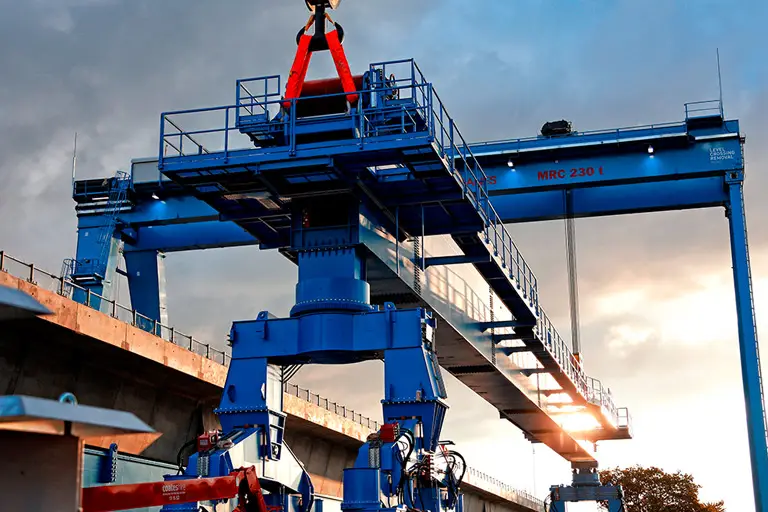 Straddle carrier installing elevated rail spans Level Crossing Removal Project Melbourne infrastructure