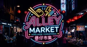 Neon Alley Market sign illuminated at night in Adelaide's Chinatown with market stalls, lanterns and visitors.